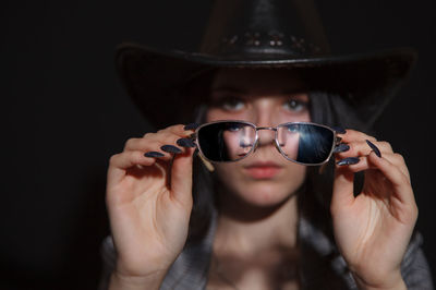 Portrait of young woman holding sunglasses