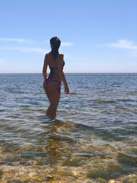 Full length of woman standing on beach against sky