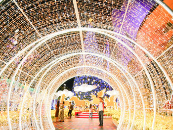 People in illuminated corridor