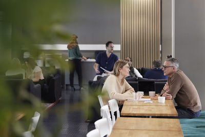 Two professionals working together in office cafeteria