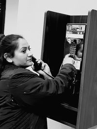 Side view of teenage boy looking through mobile phone at home