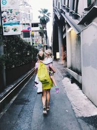 Rear view of woman walking on street in city