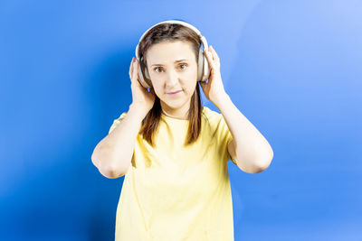 Portrait of young woman standing against blue sky