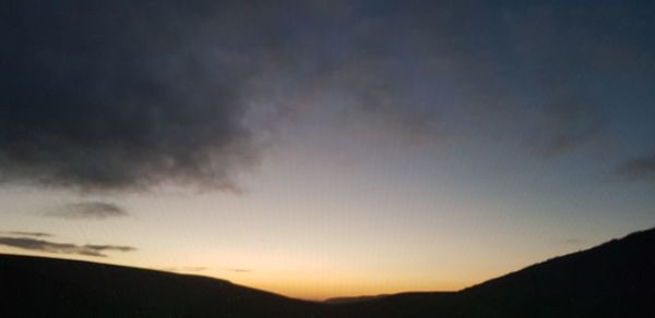 Low angle view of silhouette mountain against dramatic sky