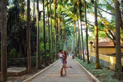 Full length of woman walking on palm trees at beach