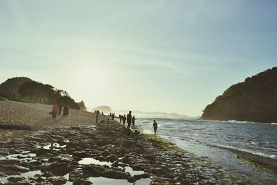 People at beach against sky