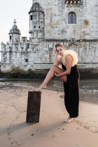 Model standing by the belem tower in lisbon, portugal