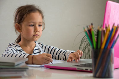 Girl using laptop while studying at home