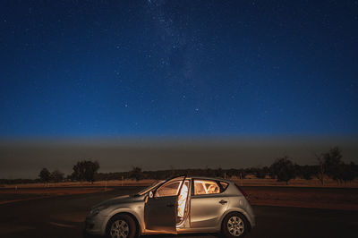 Car on road against blue sky at night