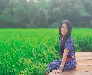 Portrait of woman sitting on field