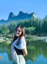 Woman with reflection in lake against sky