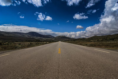 Road by mountain against sky