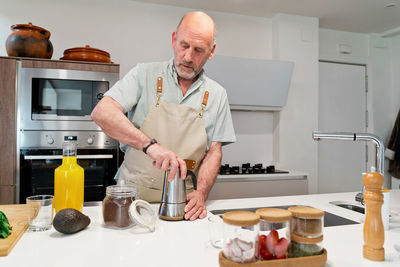 Full length of man standing in kitchen at home