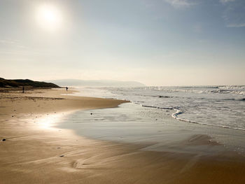 Scenic view of beach against sky during sunset