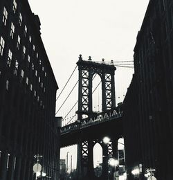 Low angle view of bridge and buildings against sky