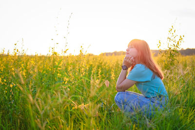 Rear view of woman standing on field