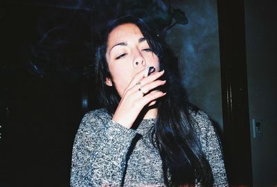 Close-up of young woman smoking cigarette