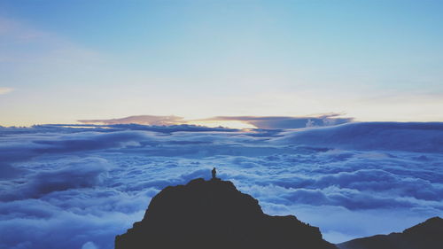 Silhouette mount rinjani volcano with cloudscape against sky during sunrise