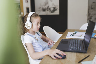 Close-up girl using laptop at home