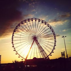 Low angle view of silhouette ferris wheel against sky at night