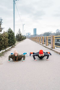 Two fit woman friends exercising outdoor. girl friends doing plank pose exercise outdoors. 