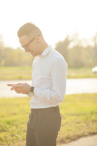 Side view of young man using mobile phone