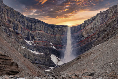 Beautiful cascades of scenic hengifoss falling from mountains during sunset