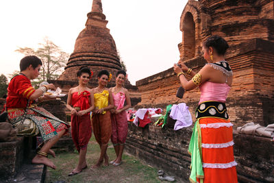 Group of people outside temple against building