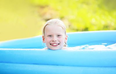 Girl sitting in wading pool at lawn