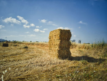 Hay bales on field against sky