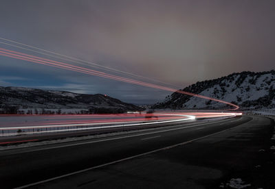 Road passing through illuminated city at night