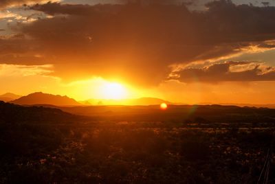 Scenic view of silhouette field against sky during sunset