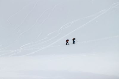 People skiing on mountain during winter