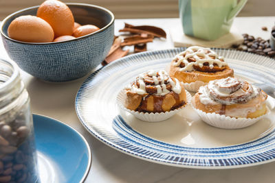 Cinnamon rolls, freshly baked on a plate kitchen tabletop - baking and home cooking concept image.