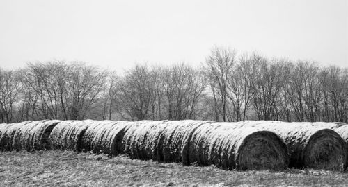 Hay bales on field against clear sky