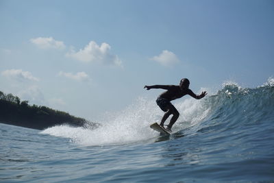 Full length of man splashing water in sea