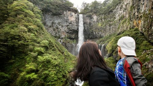 Rear view of woman looking at waterfall