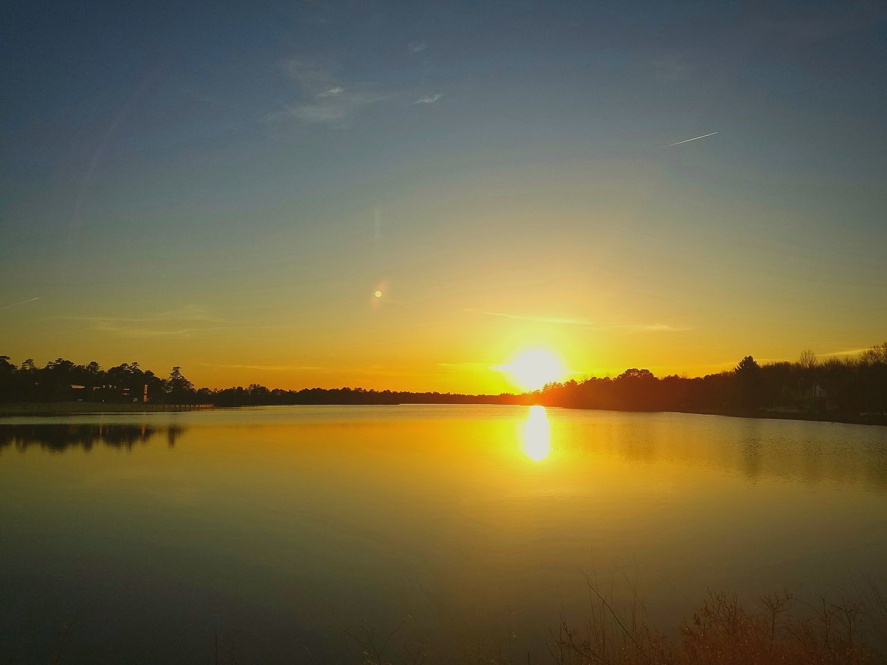 sunset, water, tranquil scene, scenics, reflection, tranquility, sun, beauty in nature, silhouette, idyllic, lake, orange color, nature, copy space, sky, waterfront, clear sky, sunlight, calm, outdoors