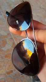 Close-up of cropped hand holding sunglasses