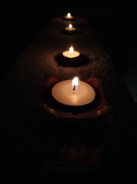 High angle view of lit candle in darkroom