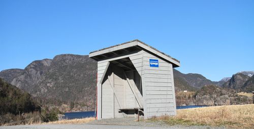 Built structure on field against clear blue sky