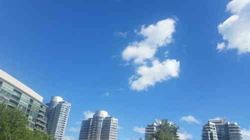 Low angle view of skyscrapers against blue sky