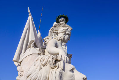 Low angle view of statue against blue sky