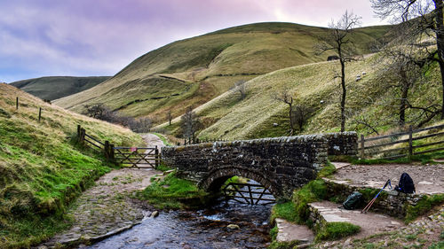 Arch bridge over mountains against sky