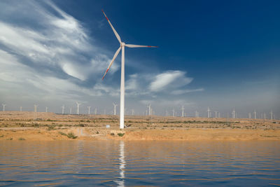 Wind turbines on land against sky