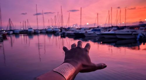 Reflection of person on sailboat in sea against sky during sunset