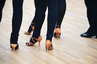 Low section of people standing on hardwood floor