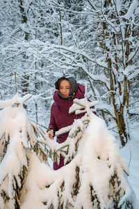 Beautiful woman in a warm coat in winter in a forest covered with snow person