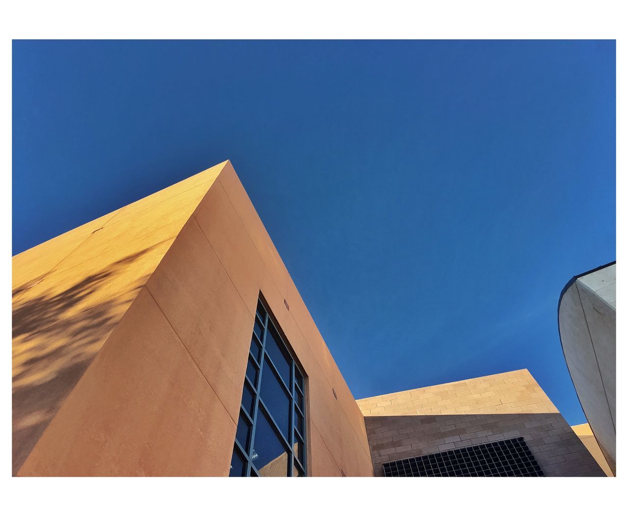 LOW ANGLE VIEW OF BUILDING AGAINST CLEAR BLUE SKY