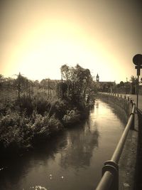 Bridge over river in city against clear sky